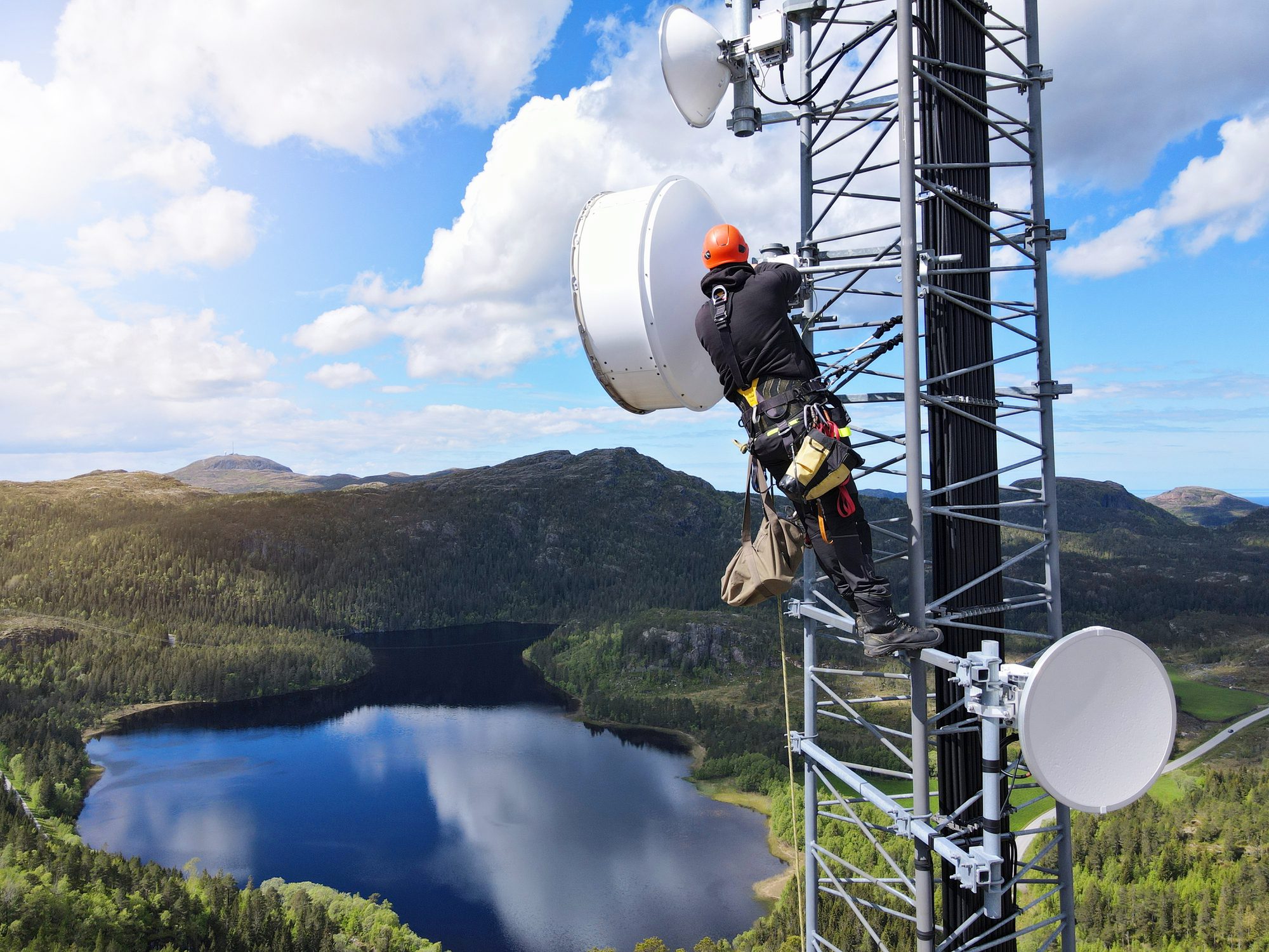 Climber maintaining antenna in nature setting