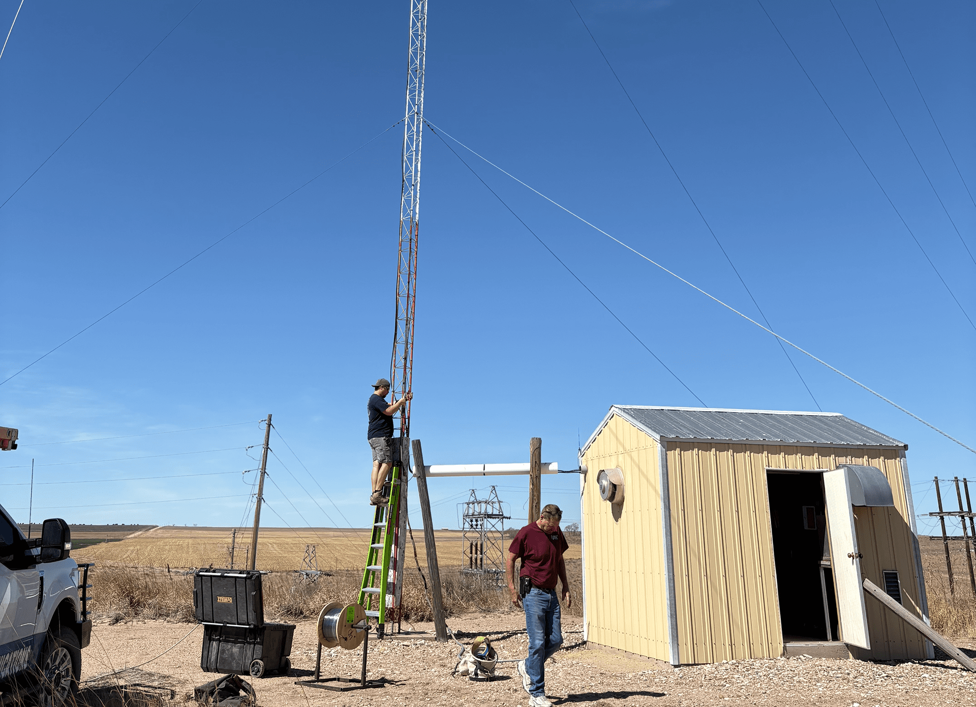 Two people working on a radio tower.