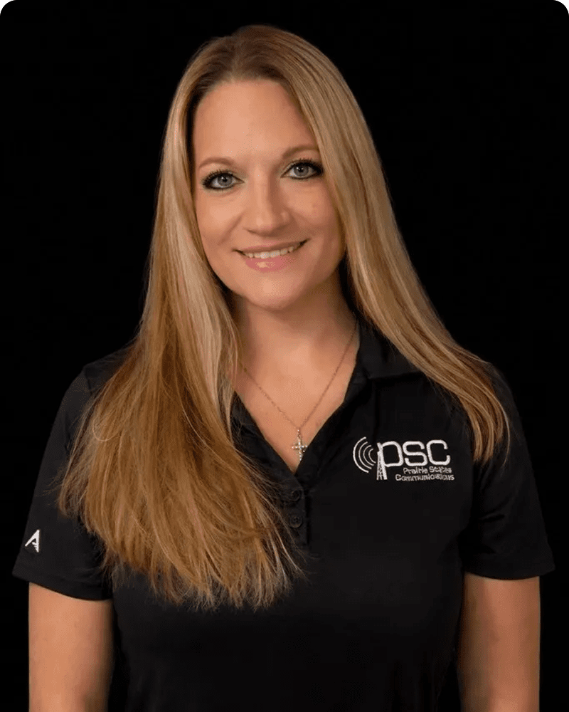 Woman in black PSC polo shirt smiling.